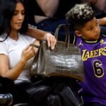 Kim Kardashian's decision to leave her $50K+ Birkin bag on the floor at an NBA game has sparked heated debate and fan reactions, highlighting the intersection of luxury fashion and celebrity culture.